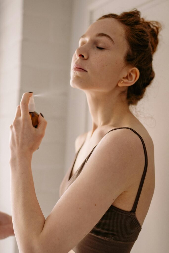 A woman spraying mist on her face